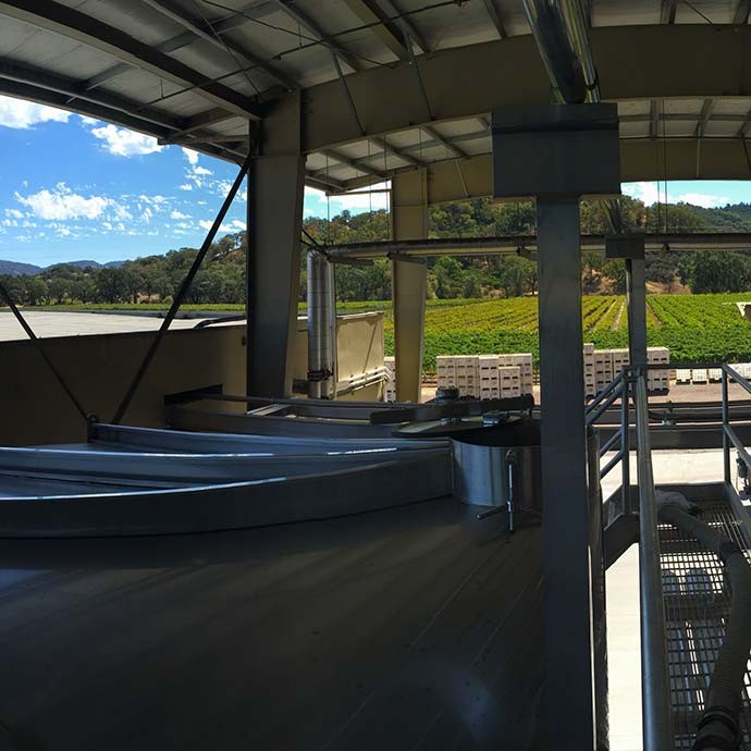 Tanks with a vineyard view at winemaking location in Hopland