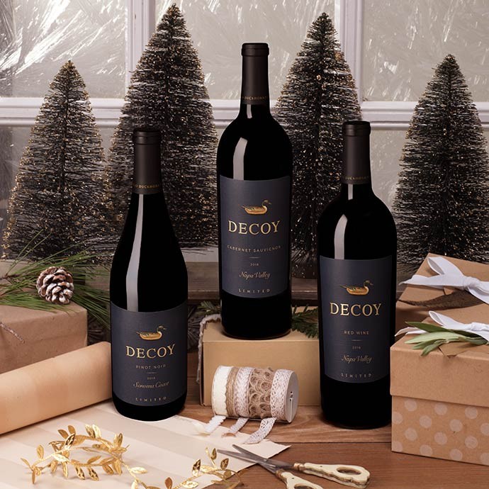 Three bottles of Decoy Limited wine bottles on a gift wrapping table